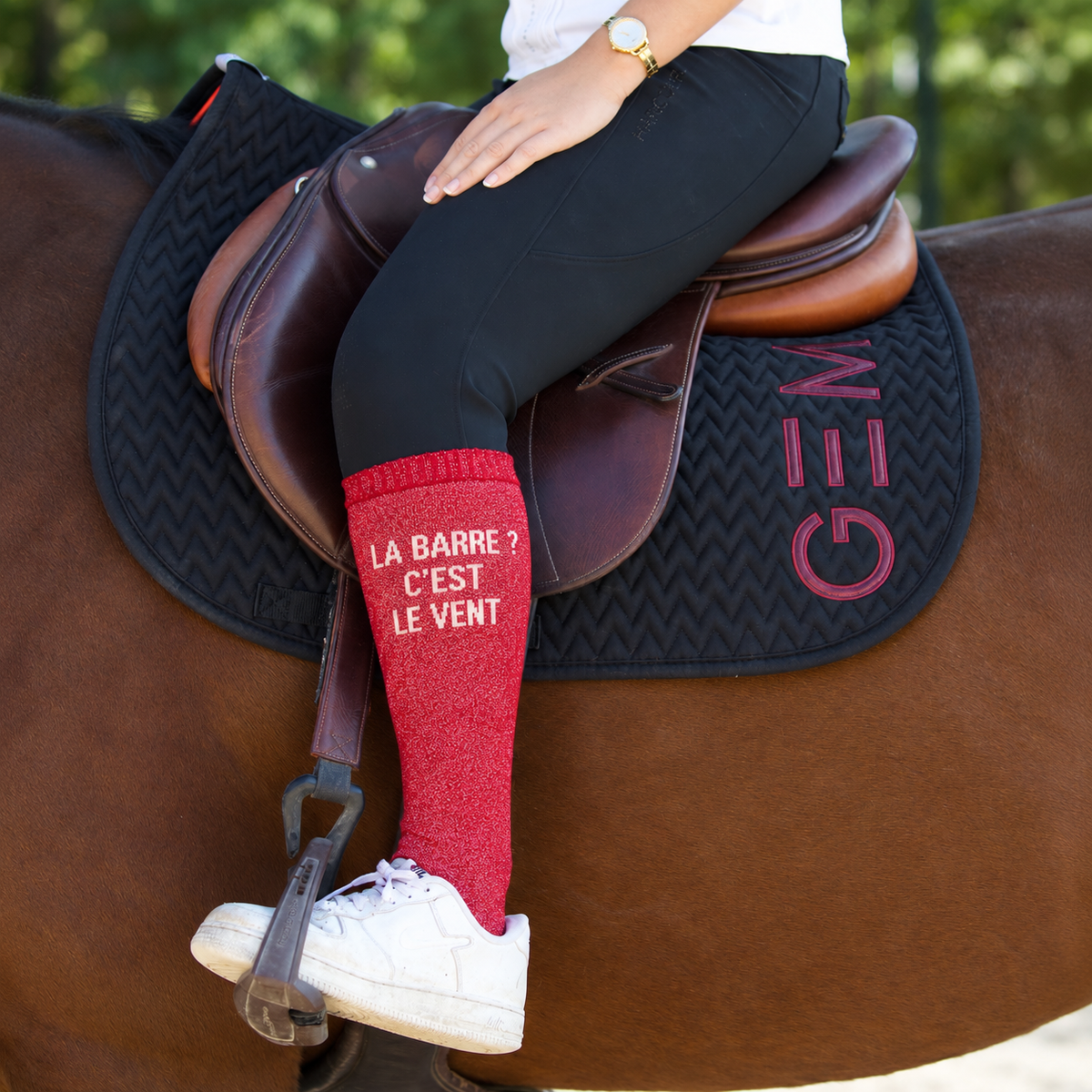 Chaussette d'équitation rouge La barre ? C'est le vent portée en selle sur un cheval bai